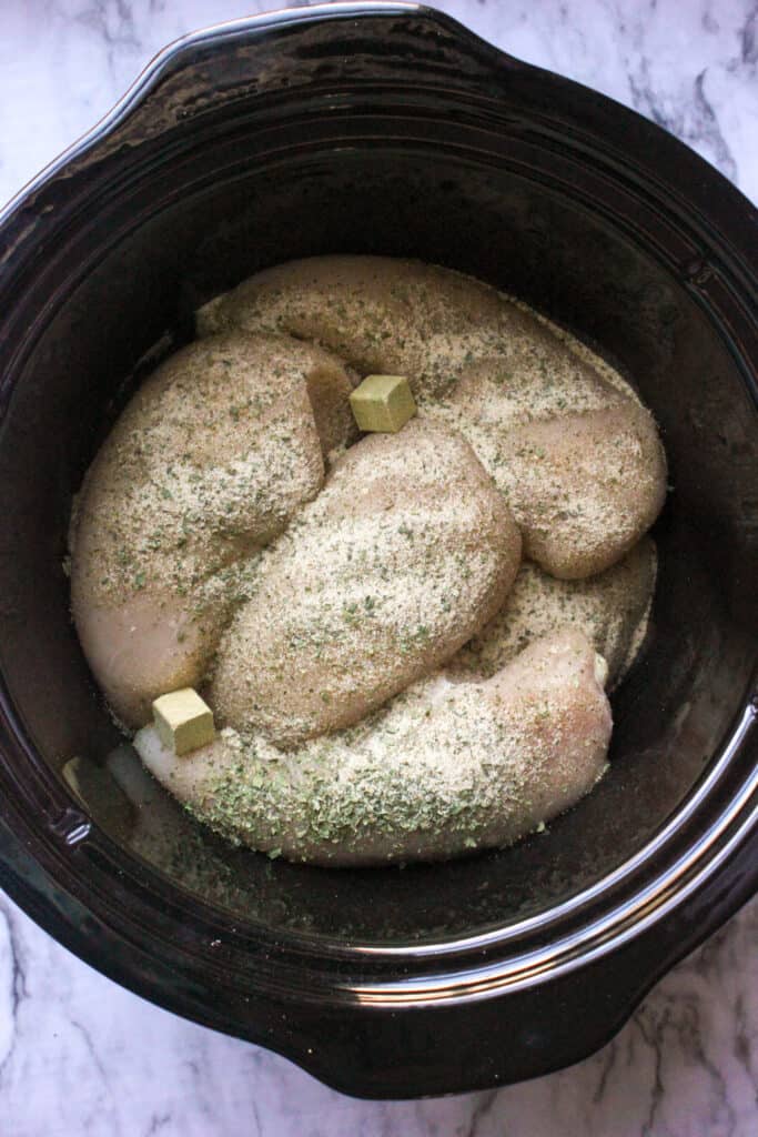 chicken and seasonings in a slow cooker