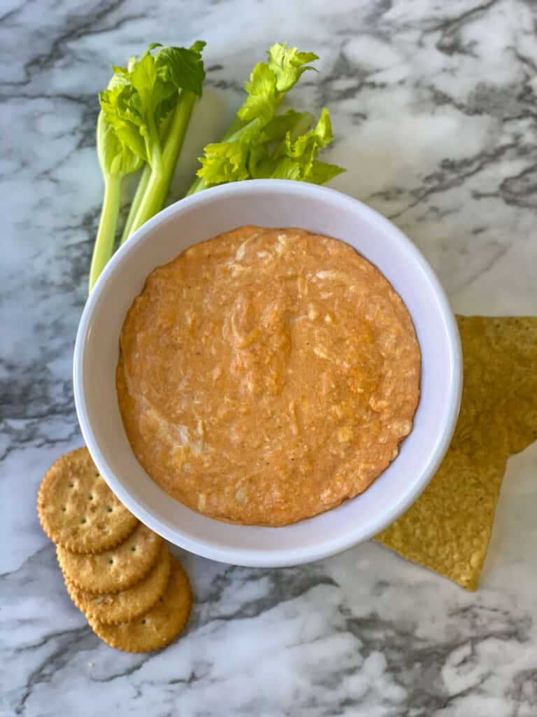 Slow Cooker Buffalo Chicken Dip with chips, crackers, and celery