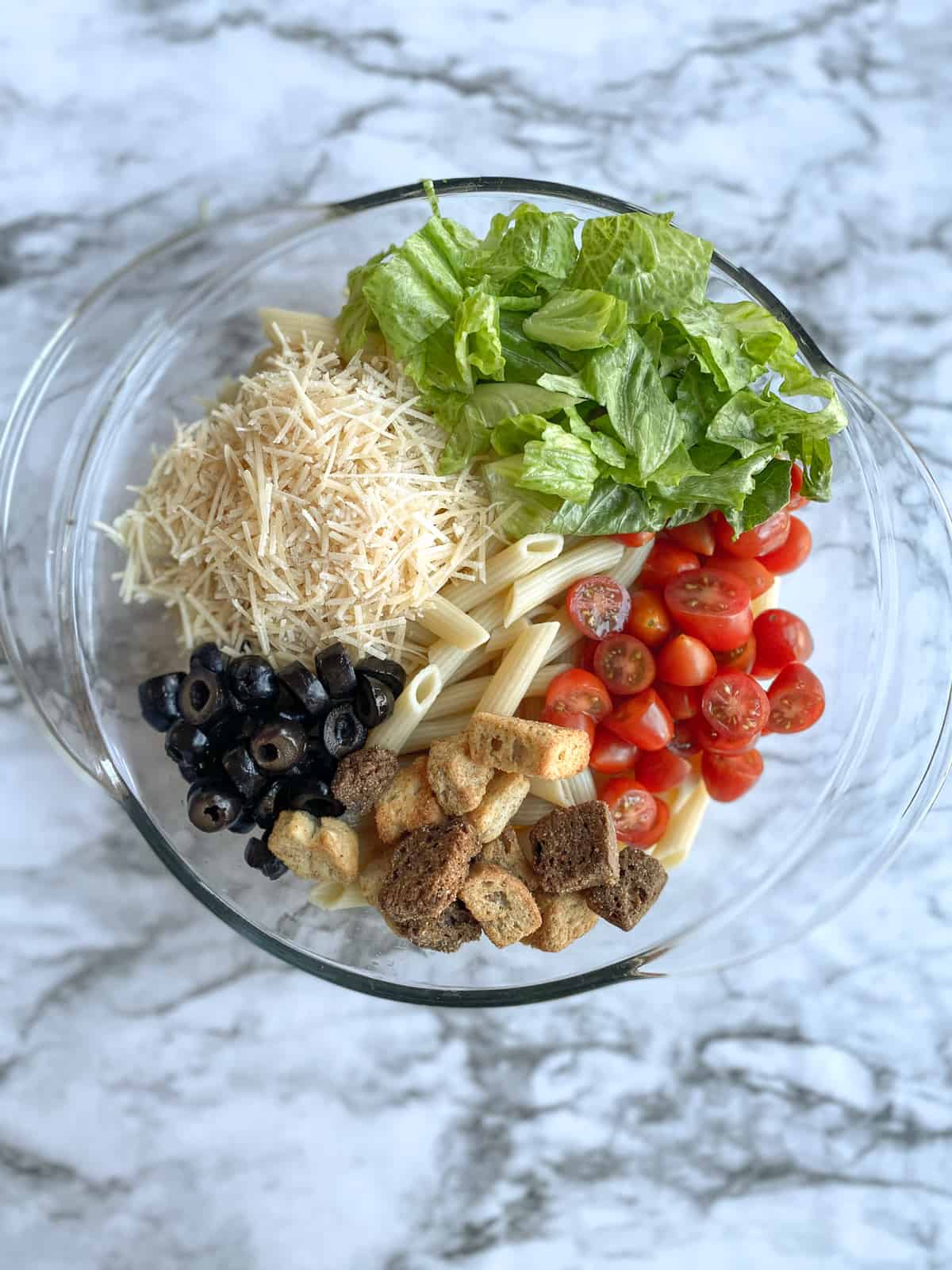 penne pasta, croutons, romaine lettuce, shredded parmesan cheese, black olives