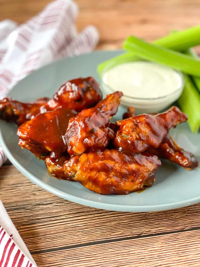 air fryer buffalo bbq chicken wings on a plate with ranch dressing and celery