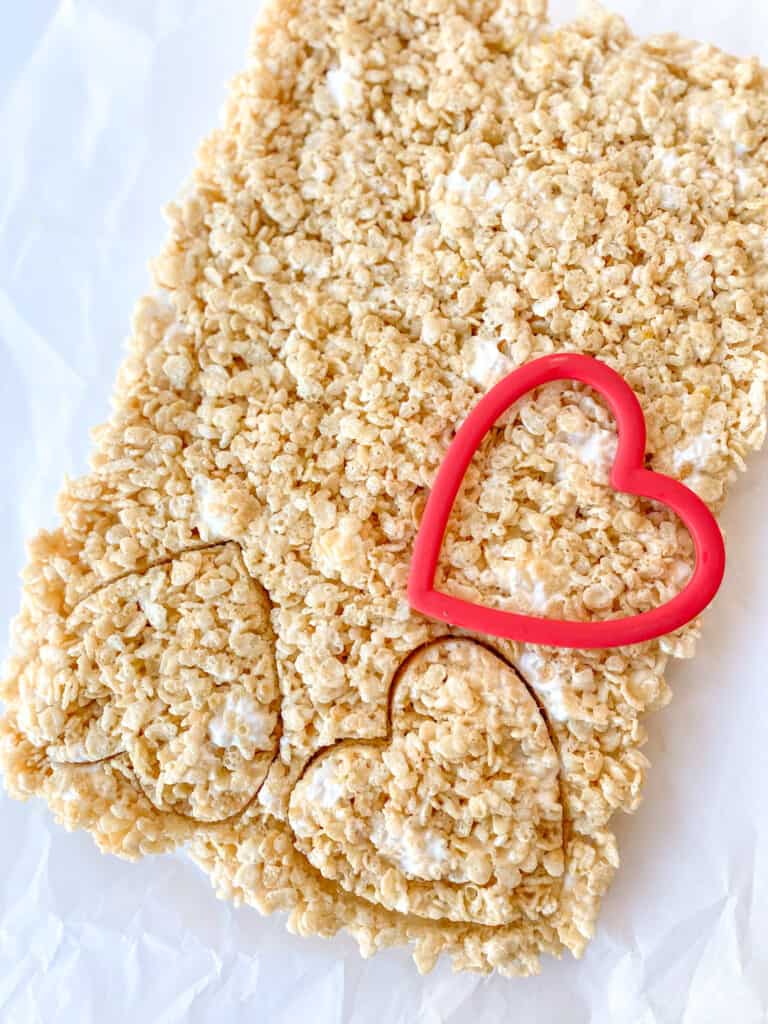 cutting out rice krispies with a heart cookie cutter