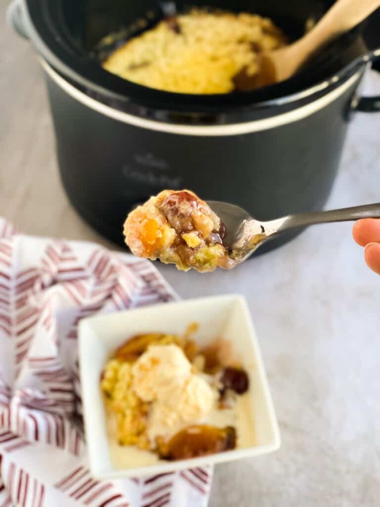 slow cooker strawberry peach dump cake on a spoon, in the crock pot, and in a dish with ice cream on top