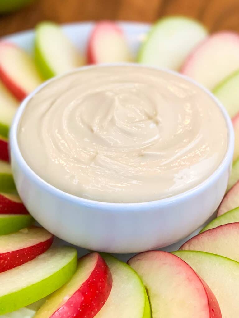 close up of apple dip in a bowl with apples on the plate