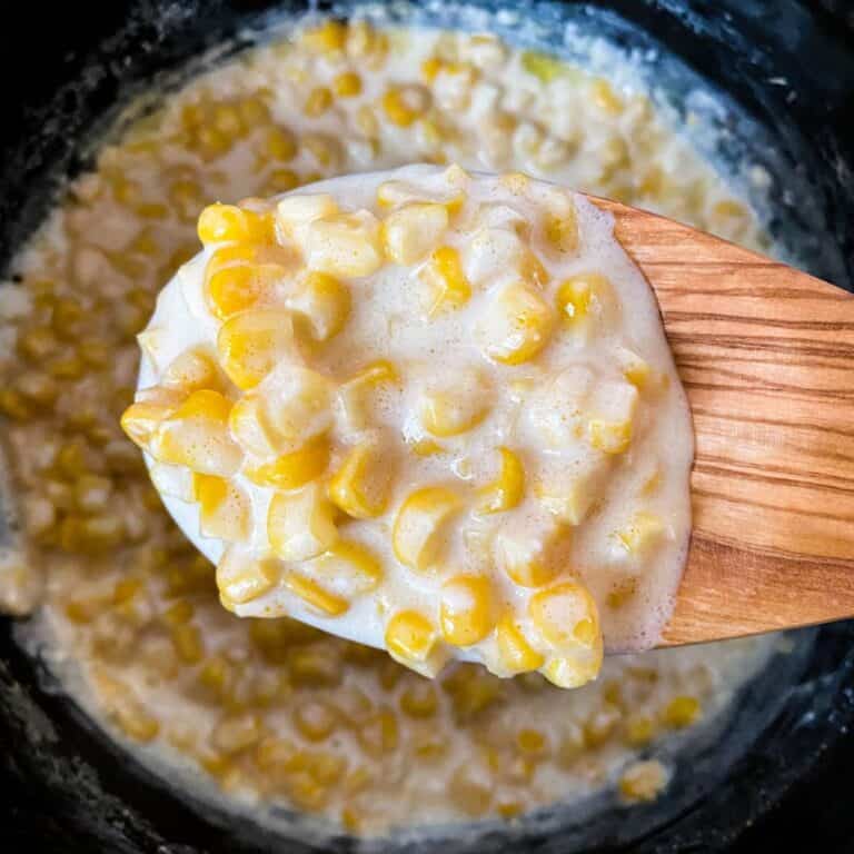 5 Ingredient Slow Cooker Creamed Corn on a spoon and in a crockpot