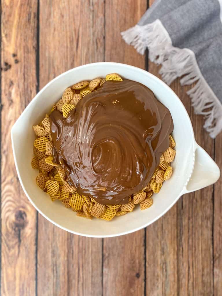 crispix in a bowl with melted chocolate and peanut butter on top