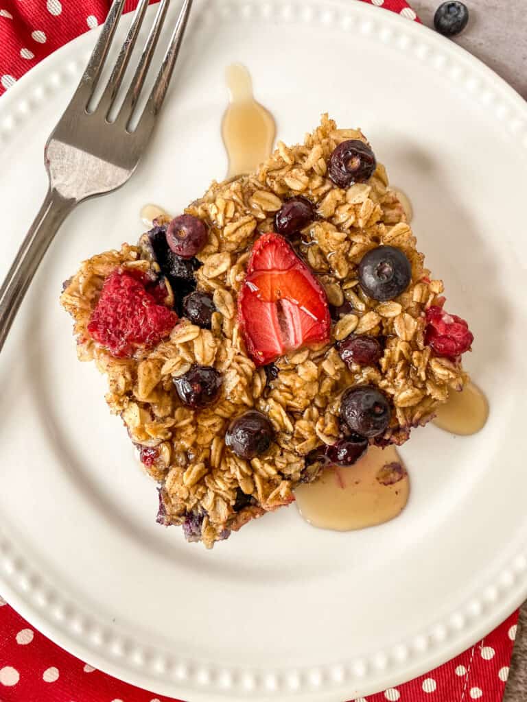 close up of easy mixed berry baked oatmeal with maple syrup on top