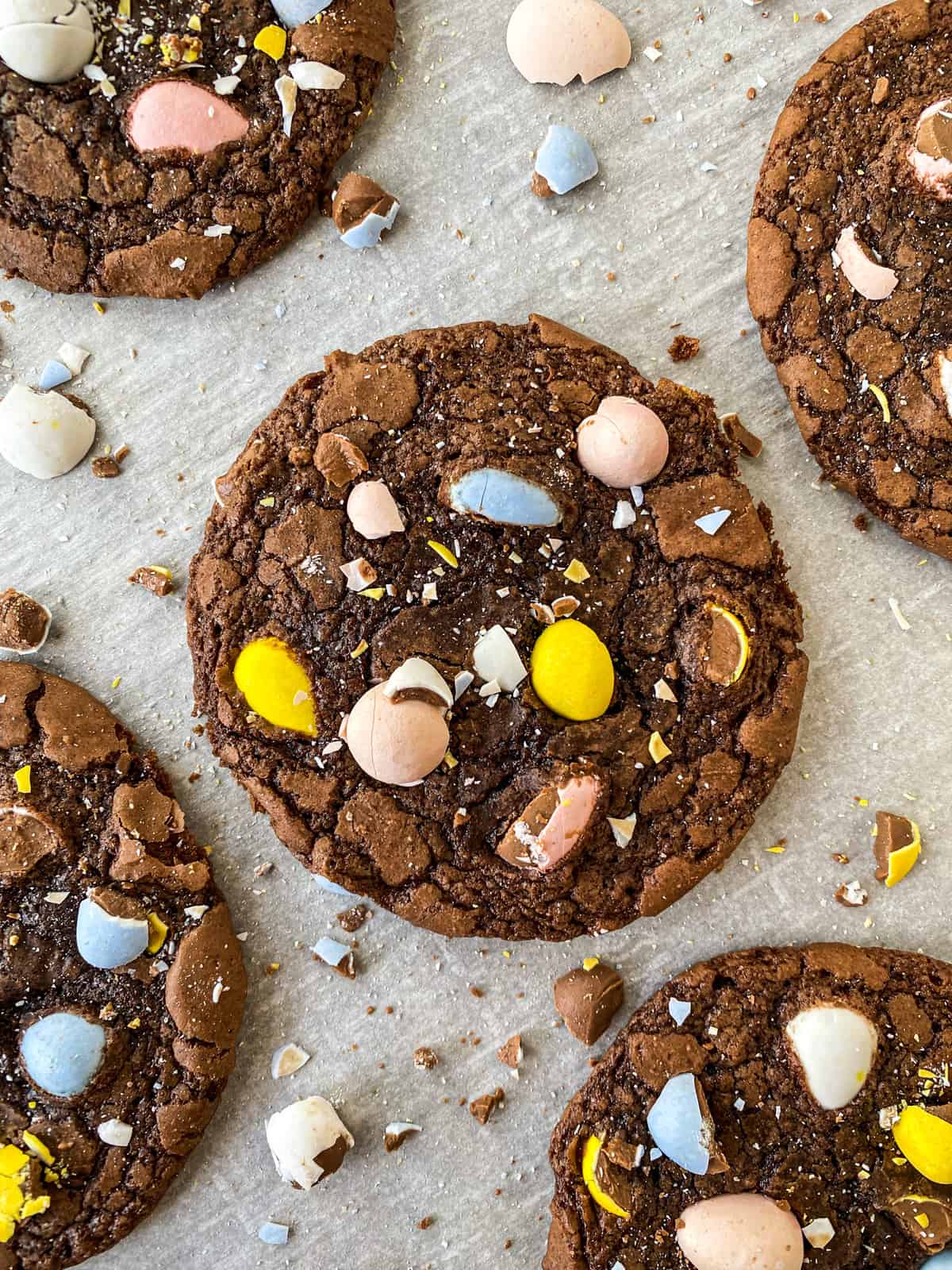 close up of cadbury egg brownie mix cookies on a baking sheet with crushed eggs around