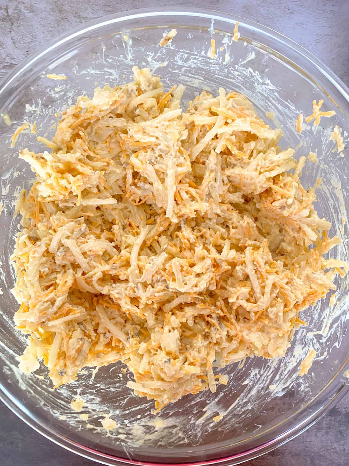 hash brown casserole ingredients mixed together in a bowl