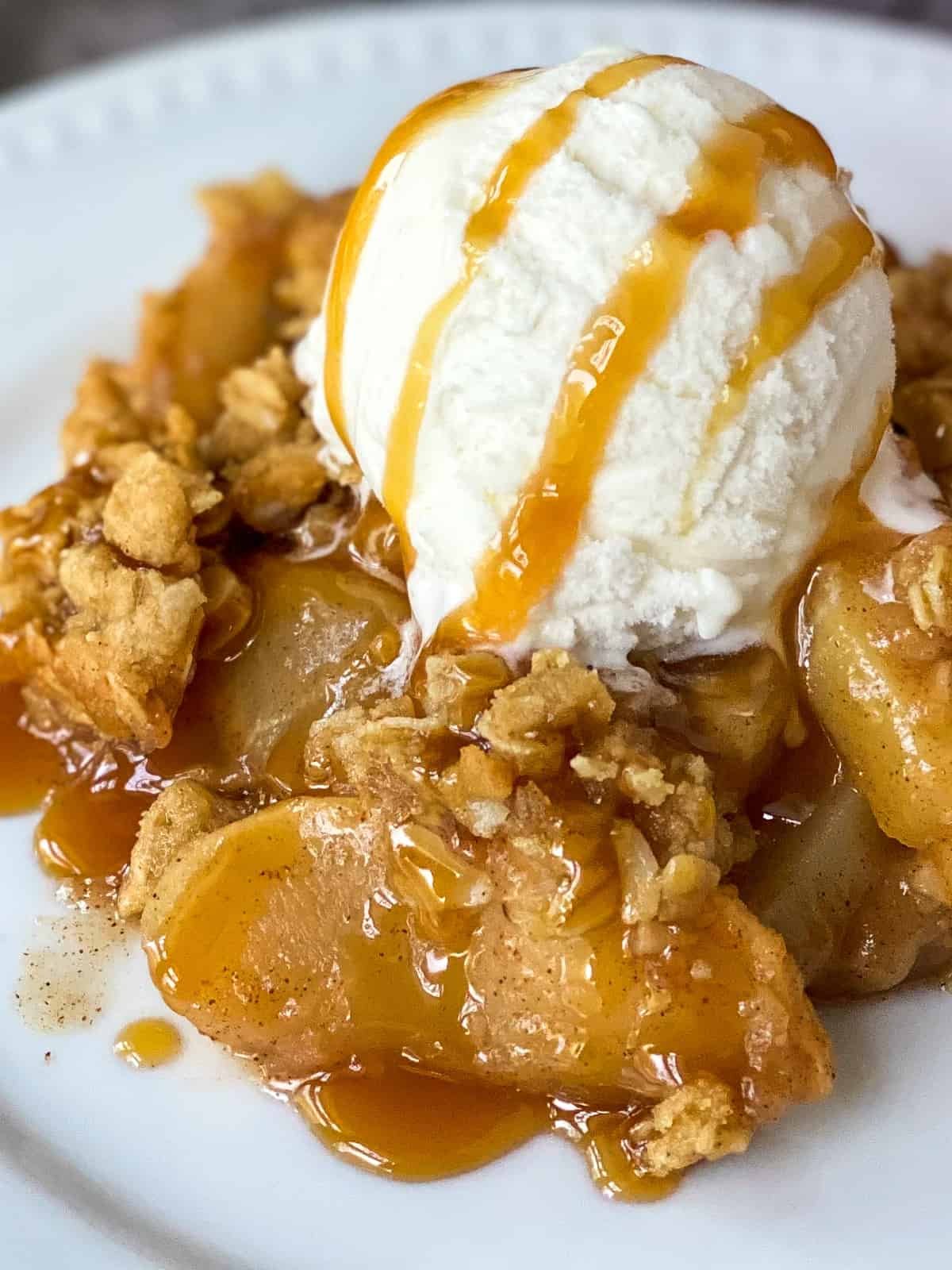 close up of a plate of crisp with ice cream and caramel on top