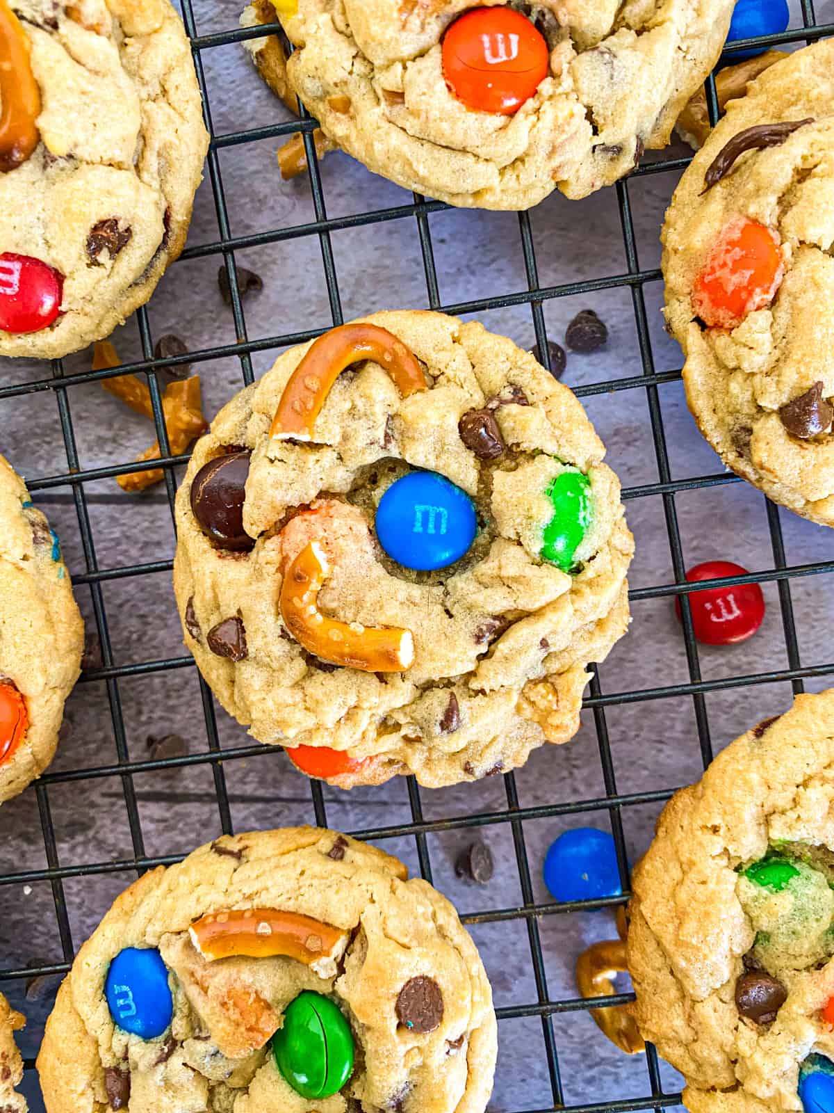 cookies on a baking sheet with m&m's and chocolate chips scattered underneath