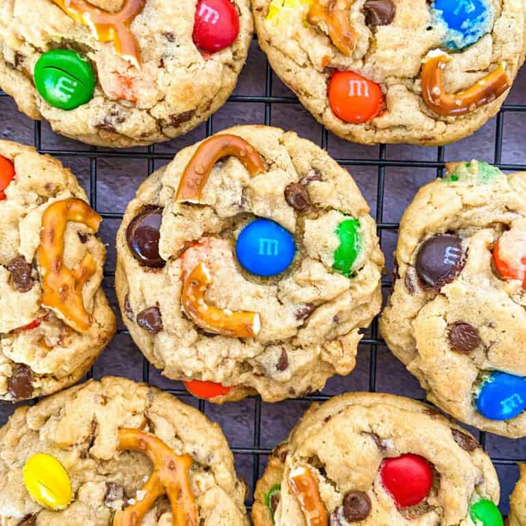 a close up of a baking tray full of peanut butter pretzel m&m cookies