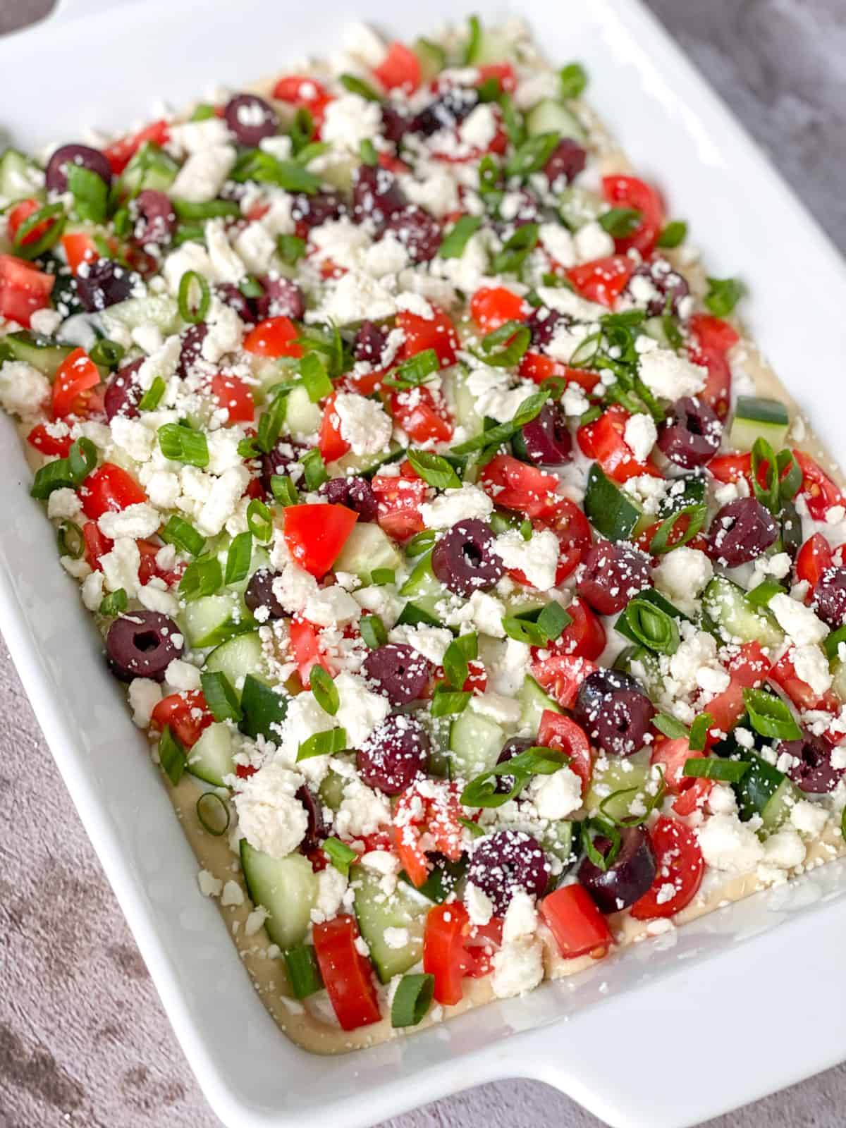 close up of the greek 7 layer dip in a pan