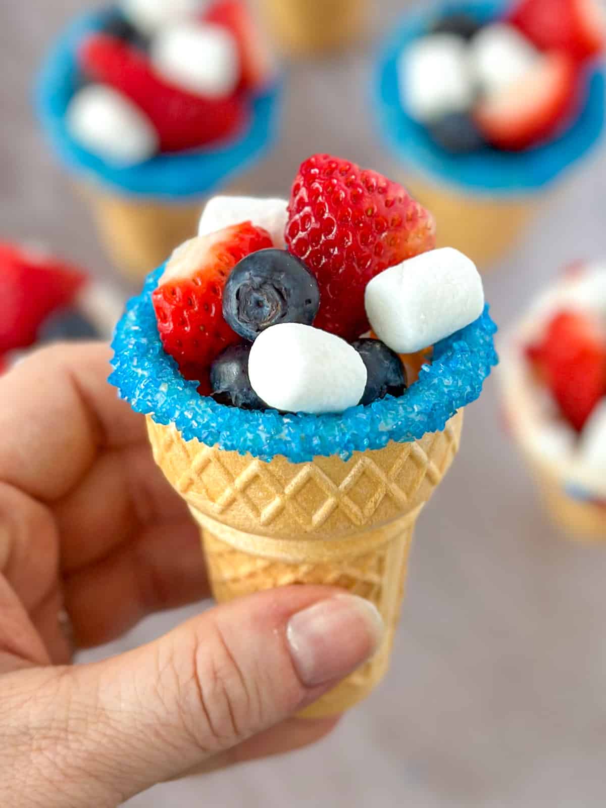 close up of a patriotic fruit ice cream cone with more in the background