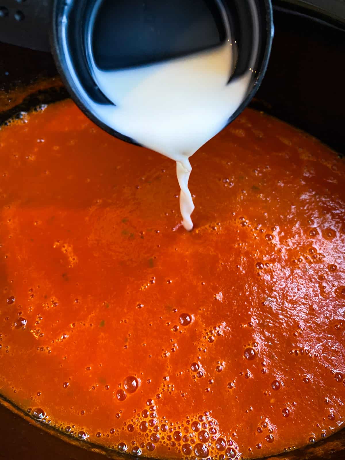 milk being poured into the crock pot