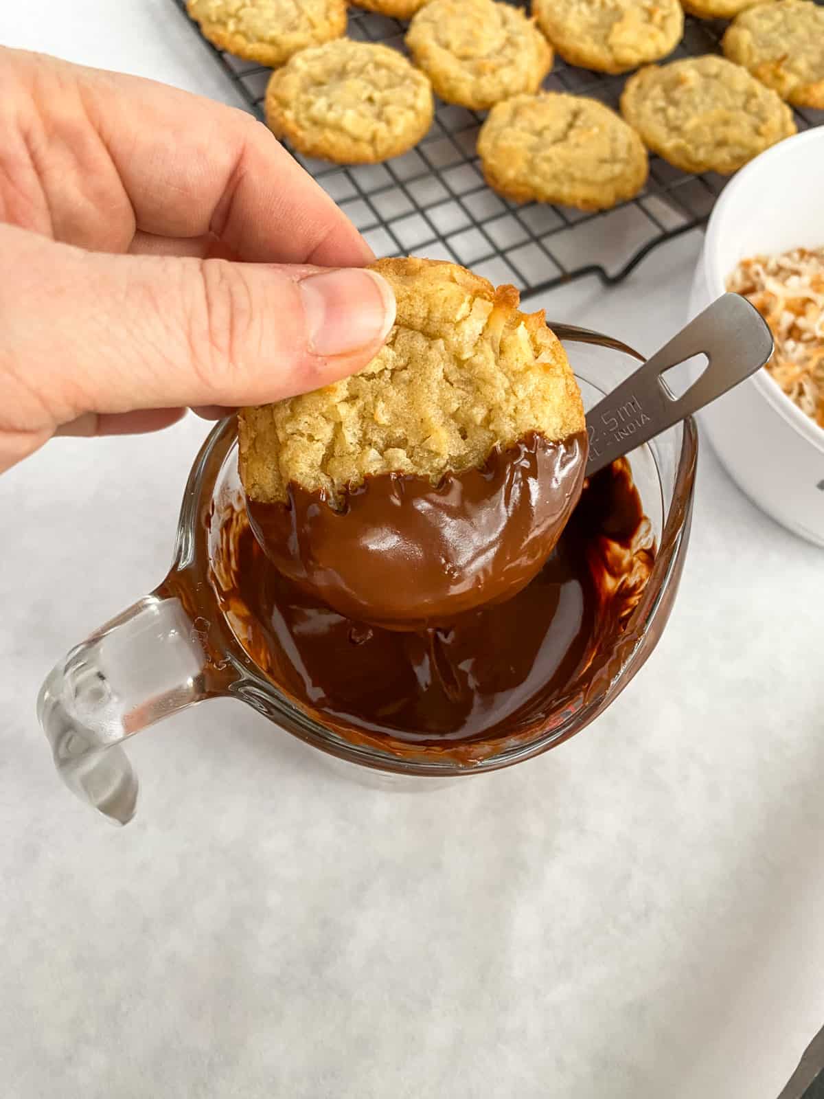 Dipping the cookies in melted chocolate.