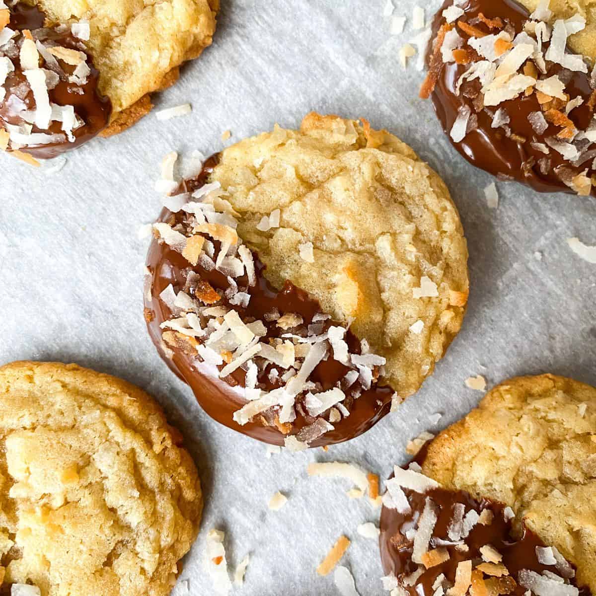 Chocolate Dipped Coconut Cookies on parchment paper on a baking sheet.