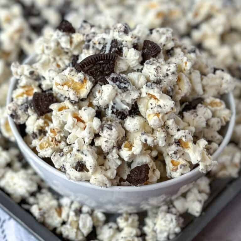 Cookies and Cream Oreo Popcorn in a bowl with more in a baking pan.