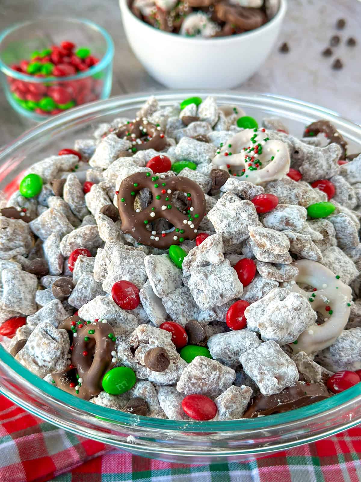 Christmas Reindeer Chow Snack Mix in a bowl with a small bowl of m&ms and chocolate covered pretzels next to it.