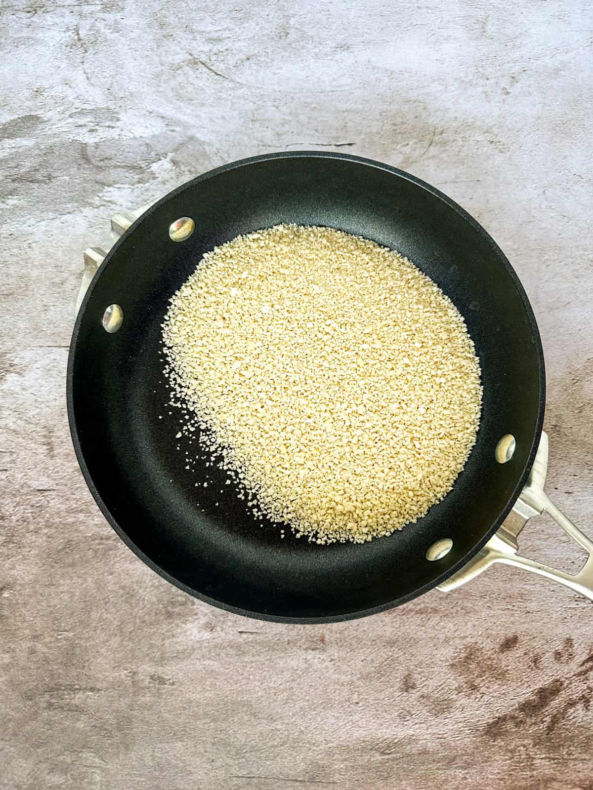 Panko bread crumbs toasting in a skillet.