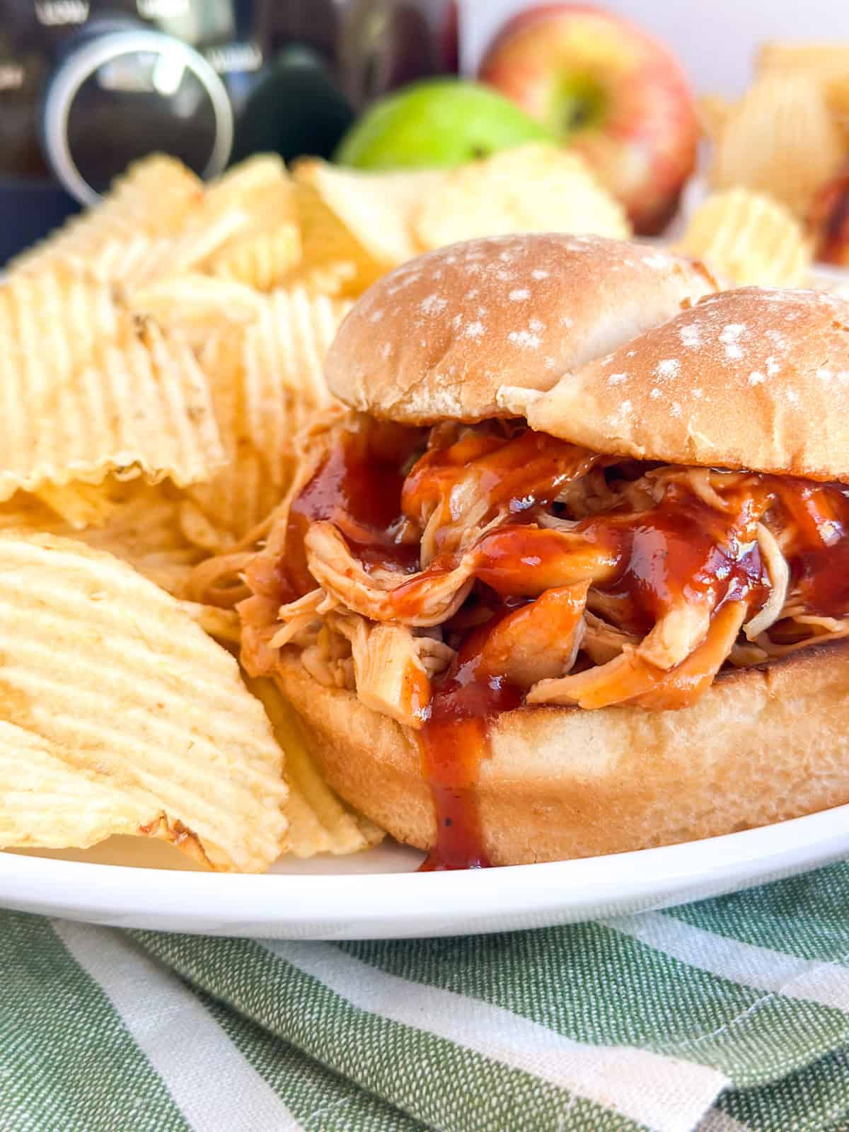 Apple BBQ Chicken Sandwich on a plate with chips.
