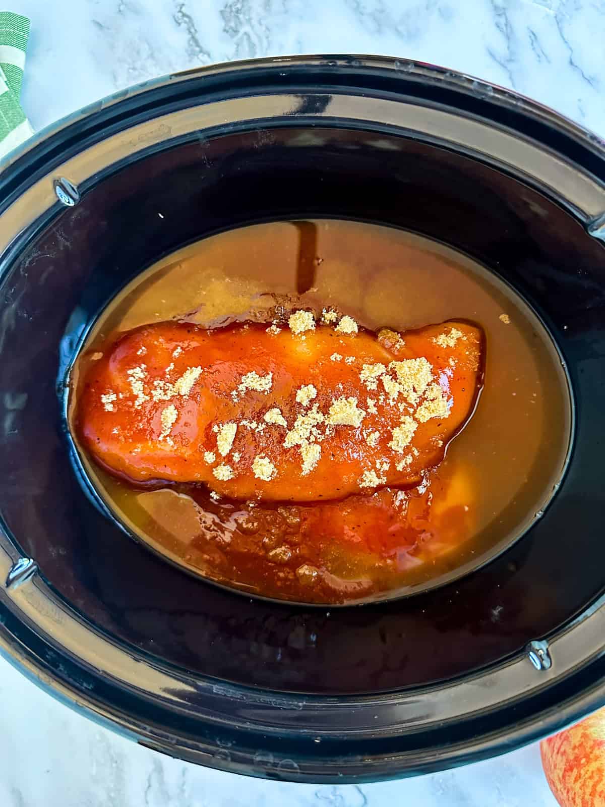 Apple BBQ Chicken in the crock pot before it is cooked.